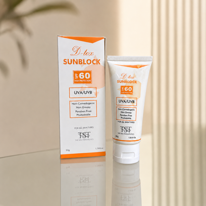 D-tee Sunblock SPF 60 UVA/UVB non-comedogenic sunblock shown in its white and orange retail box alongside the matching squeeze tube, set on a reflective beige surface against a soft beige background.