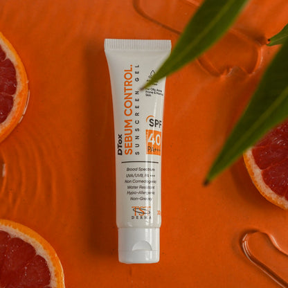 Tube of DTOX Sebum Control Sunscreen Gel on an orange surface with grapefruit slices and leaves. Price of DTOX Sebum Control Sunscreen Gel 1320 Rs